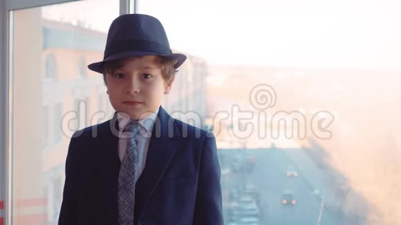 穿着商务服戴着领带和帽子的年轻男孩在办公室背景上的肖像视频的预览图