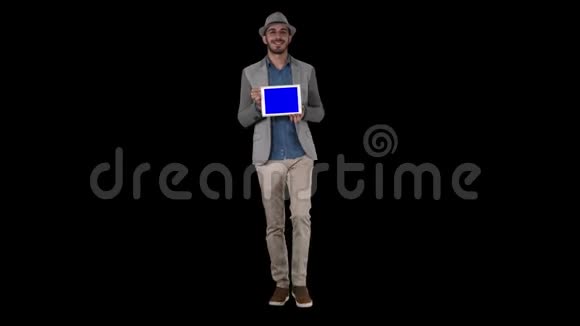 戴着帽子走路的闲人向摄像机展示数码平板电脑阿尔法频道视频的预览图
