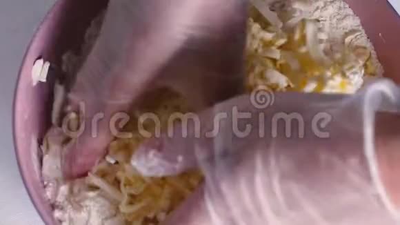 在白色面粉上用粉红色的面膜煮熟黄油女性手准备面团烘焙视频的预览图