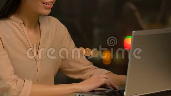 女士在笔记本电脑上打字微笑着在约会网站上交流和调情视频的预览图