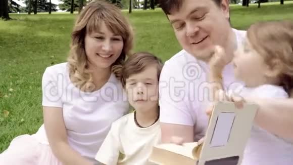 家庭幸福孩子们在户外野餐看书视频的预览图