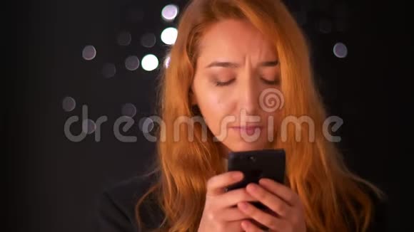 可爱的白种人生姜女孩拿着她的手机看着屏幕集中专注美丽的脸艺术视频的预览图