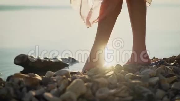 日出时在冲浪上奔跑的年轻女子美丽的腿日出时水中的雌腿视频的预览图