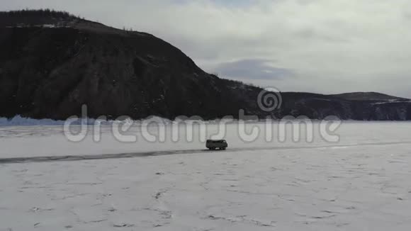 在冰冻的湖面结冰的道路上乘车旅行视频的预览图