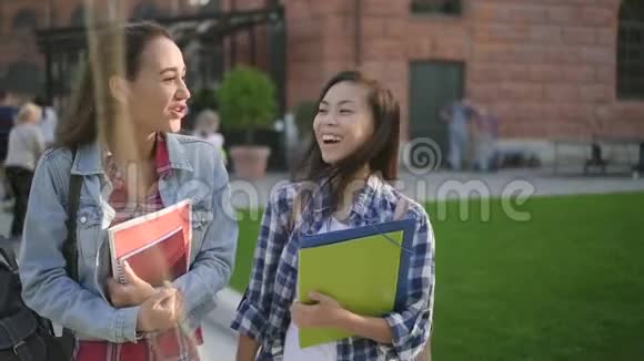 两个可爱的混血女孩在校园附近散步和交谈视频的预览图