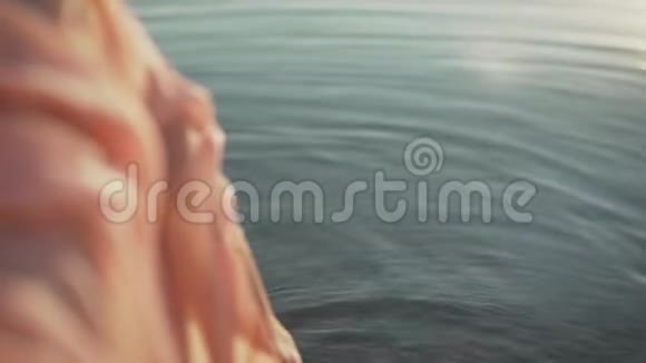 跟随一只赤脚的女性脚行走溅在海水的波浪上电影稳定镜头怀特日出时的雌腿视频的预览图