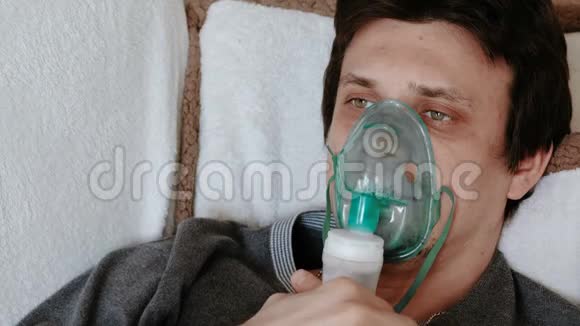 使用雾化器和吸入器进行治疗特写男人躺在沙发上用吸入面罩吸入面部前线视频的预览图