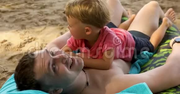 快乐的男人和孩子在海滩上视频的预览图