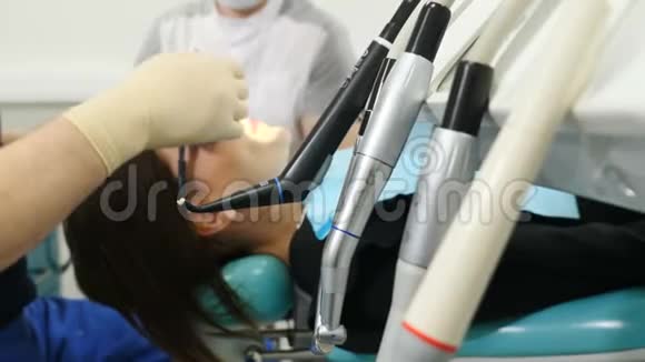 第一个计划上的牙医工具拍摄和模糊病人坐在牙医椅子上的背景医生治疗女性视频的预览图
