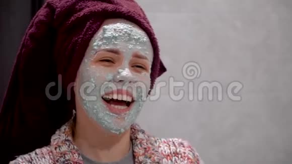迷人的年轻女子特写脸上带着化妆皮面膜女式面罩视频的预览图