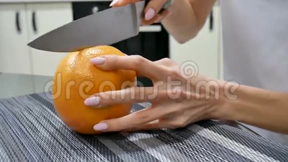 侧视女性手切新鲜葡萄柚用刀女性做水果沙拉素食观念视频的预览图
