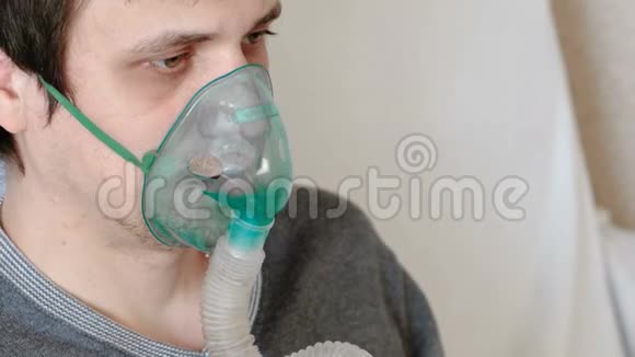 使用雾化器和吸入器进行治疗特写男人他的脸通过吸入面罩吸入前景视频的预览图