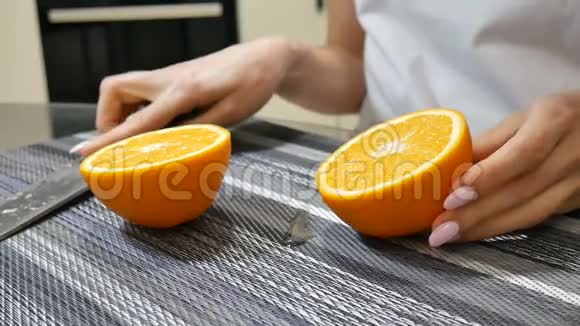 在家里的厨房里女性的双手露出两半成熟多汁的橘子视频的预览图
