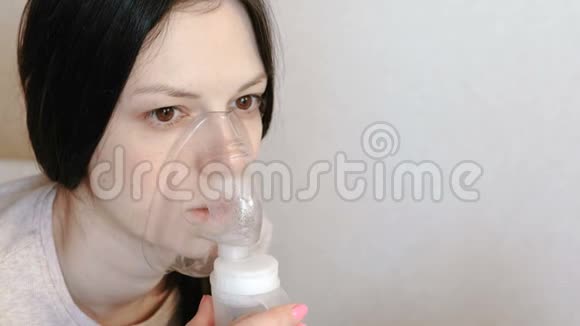 使用雾化器和吸入器进行治疗特写女人她的脸通过吸入面罩吸入前景视频的预览图