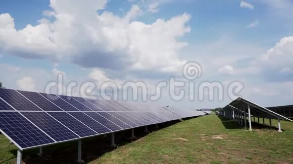 一排排的太阳能电池板在绿色的田野上对着蓝天和云彩太阳能发电站视频的预览图