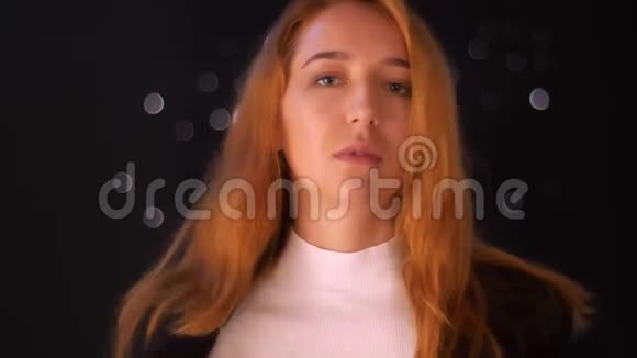 美丽的白种人正在脱下她的黑色夹克同时站在室内平静地站在孤立的地方视频的预览图