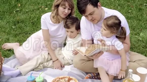 家庭幸福孩子们在户外野餐看书视频的预览图