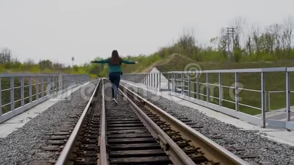 快乐的少女在铁路上奔跑视频的预览图