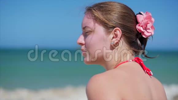 海滩上一位美丽的欧洲妇女的肖像特写镜头眺望大海的远方在海上放松视频的预览图