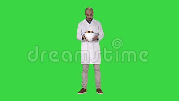 身穿白色长袍的阿拉伯工程师在绿色屏幕上戴上安全帽按Chroma键视频的预览图