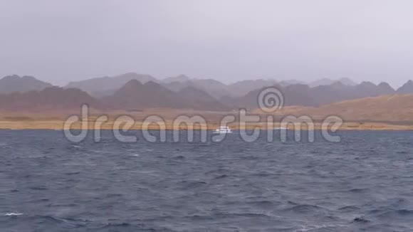 游客乘坐的游船在山峦背景下的风暴海中航行埃及视频的预览图