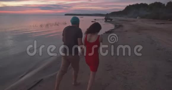 男女手牵着手在沙滩上散步视频的预览图