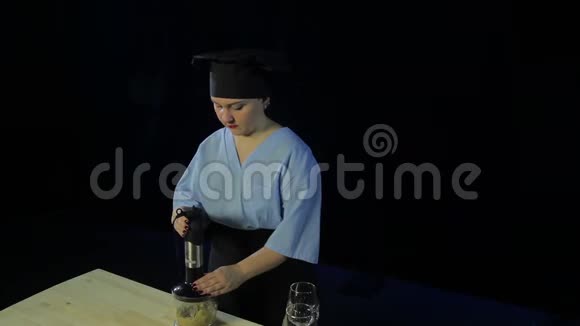 女人在黑色背景下做饭在搅拌机里切香蕉视频的预览图