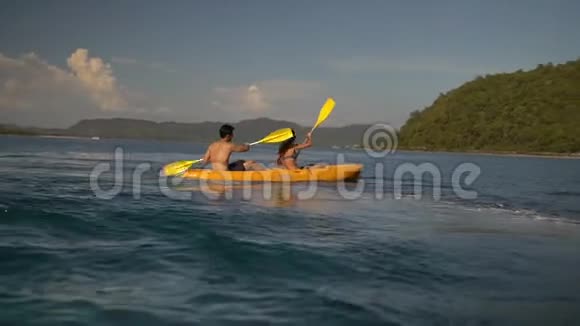一对幸福的年轻夫妇在一个热带岛屿附近的黄色皮艇上玩得很开心视频的预览图