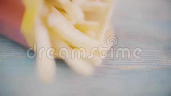 炸薯条或炸土豆落在蓝桌上特写慢镜头视频的预览图