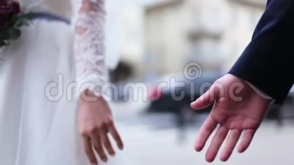 一对情侣结婚的情侣在街上牵手慢动作视频的预览图