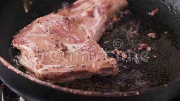 在热锅中进行特写烹饪和烤猪肉牛排视频的预览图