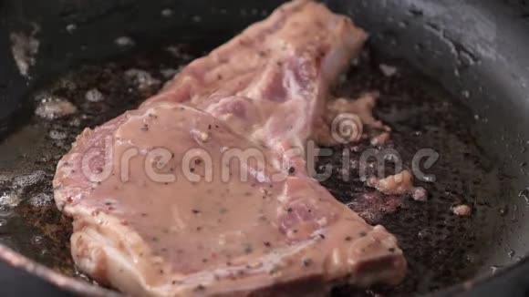 在热锅中进行特写烹饪和烤猪肉牛排视频的预览图