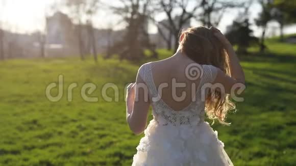 公园日落时年轻新娘的后景视频的预览图