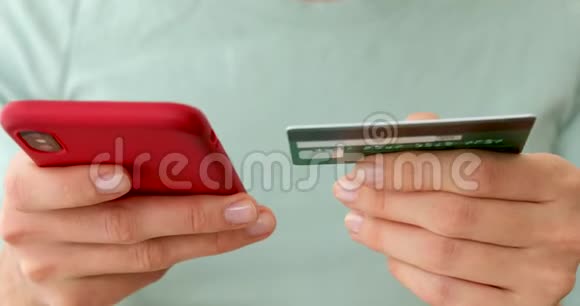 女人手里拿着信用卡用手机视频的预览图