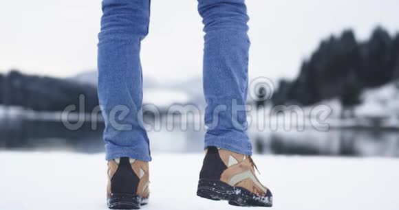 一位游客的山靴特写细节他带着一个大湖和山雪来到了令人惊叹的风景中视频的预览图