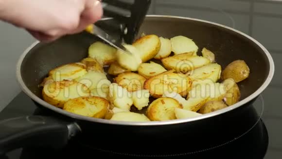 快关门用黄油炒的平底锅里的土豆一个女人用刀子把碎片翻过来食物概念视频的预览图