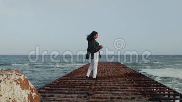 亚洲女孩在海边的码头戴上太阳镜视频的预览图