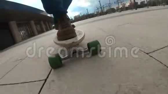 特写滑板少年骑户外一个年轻人在公园里玩长木板穿着旅行靴城市视频的预览图