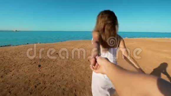 跟着我的年轻女人把她的男朋友拉到海边女孩牵着雄性的手跑到海滩上奔向大海视频的预览图