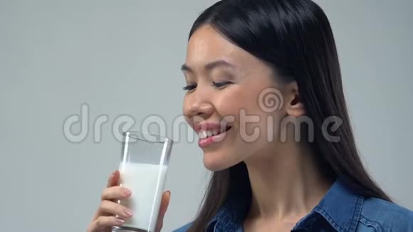 美丽的亚洲女人喝一杯牛奶健康的饮食必需的营养视频的预览图