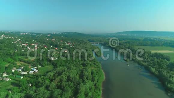 在森林里的一个小村庄里桥在河上的无人机拍摄4K视频的预览图