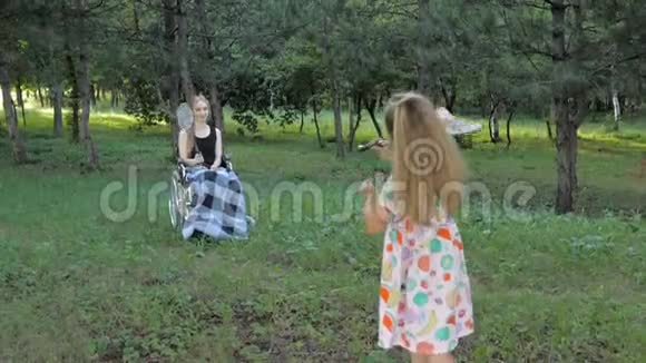 漂亮的金发女孩坐在轮椅上打羽毛球玩得很开心视频的预览图