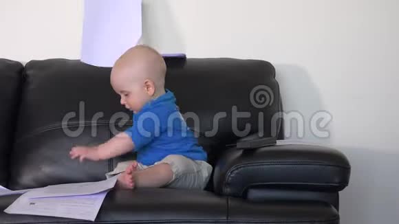 可爱的小男孩在沙发上玩文件视频的预览图