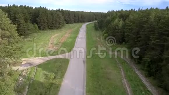 绿色密林环绕的灰色柏油路视频的预览图