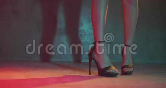 特写女足穿着高跟鞋在工作室里用霓虹灯跳舞视频的预览图