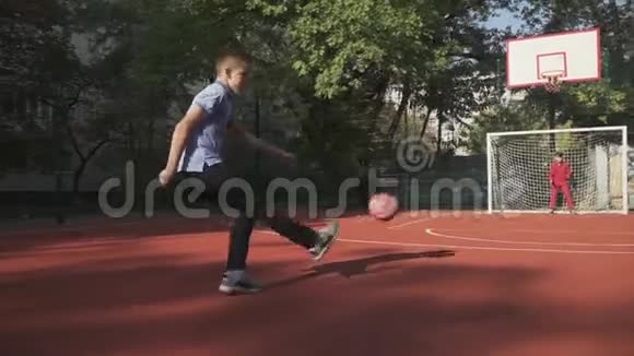 两个男孩在户外踢足球男孩踢球得分视频的预览图