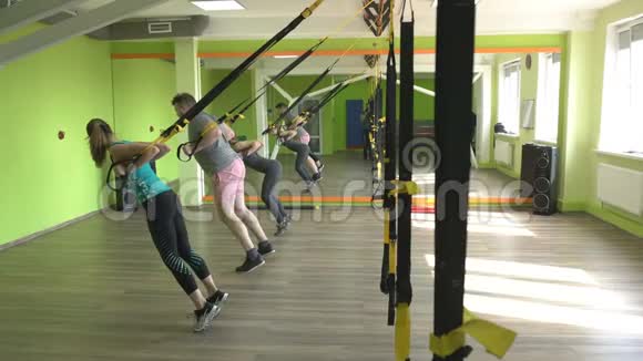 健身房里的人都参与到TRX循环中对三头肌进行伸展运动增强肌肉视频的预览图
