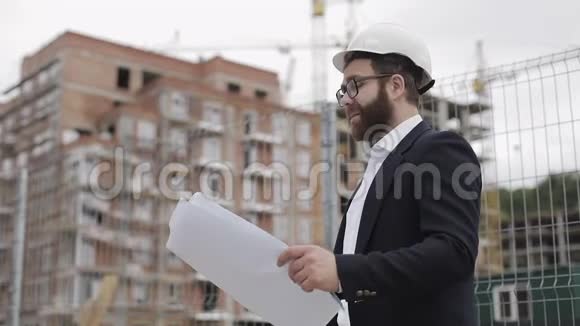 建筑工地上英俊的年轻工程师看相机的肖像建造建筑工程的建筑工人视频的预览图