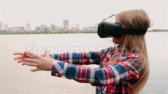 一个金发女孩戴着眼镜穿着一件格子衬衫站在靠近大海的大城市的背景上视频的预览图