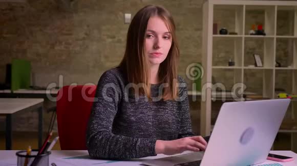 正坐在办公室里的白种人生姜女人观察着smth变得非常高兴视频的预览图